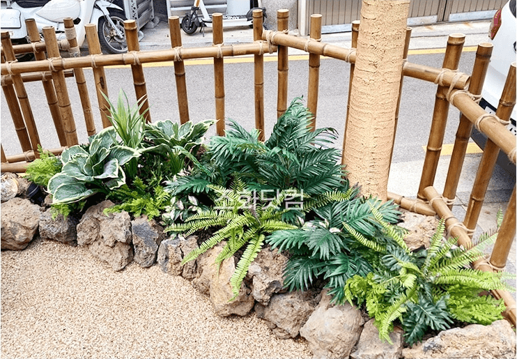 서울 에이스크랩 강남점 — 매장 코너의 화산석과 열대 식물 화단