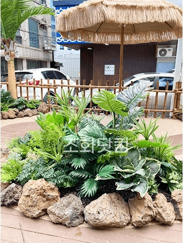 서울 에이스크랩 강남점 — 초가지붕 파라솔과 야자수 포토존