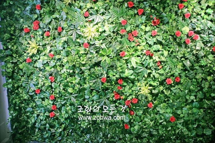 부산 플라잉볼 수제버거 — 잎과 장미가 어우러진 벽