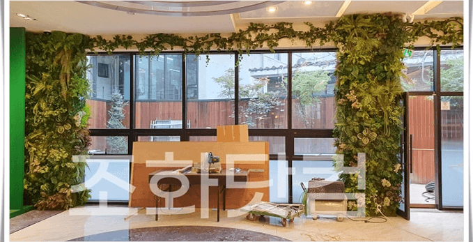 강남 명품멀티샵 — 대리석과 컬러 포인트, 초록이 어우러진 매장 실내 전경