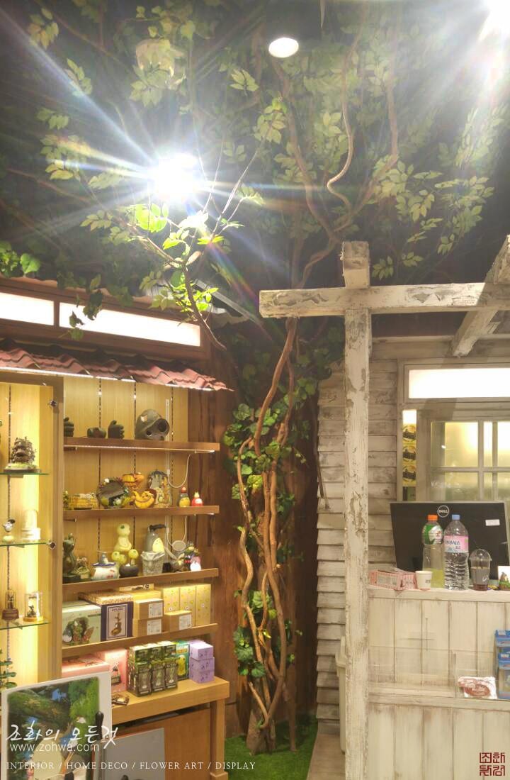 용산 아이파크몰 도토리숲 — 진열장 위로 드리운 나뭇가지