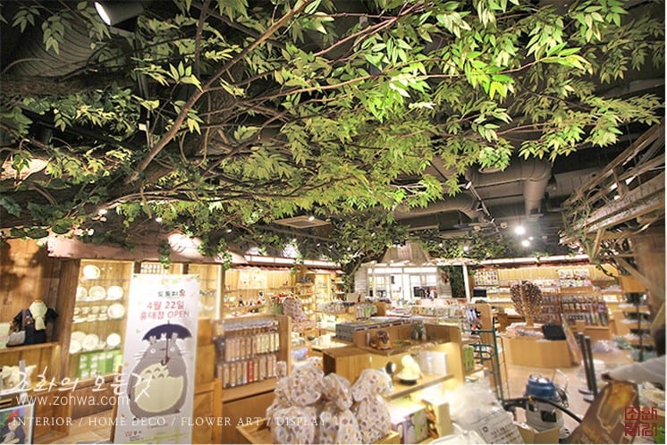 용산 아이파크몰 도토리숲 — 나무 아래 진열된 캐릭터 굿즈