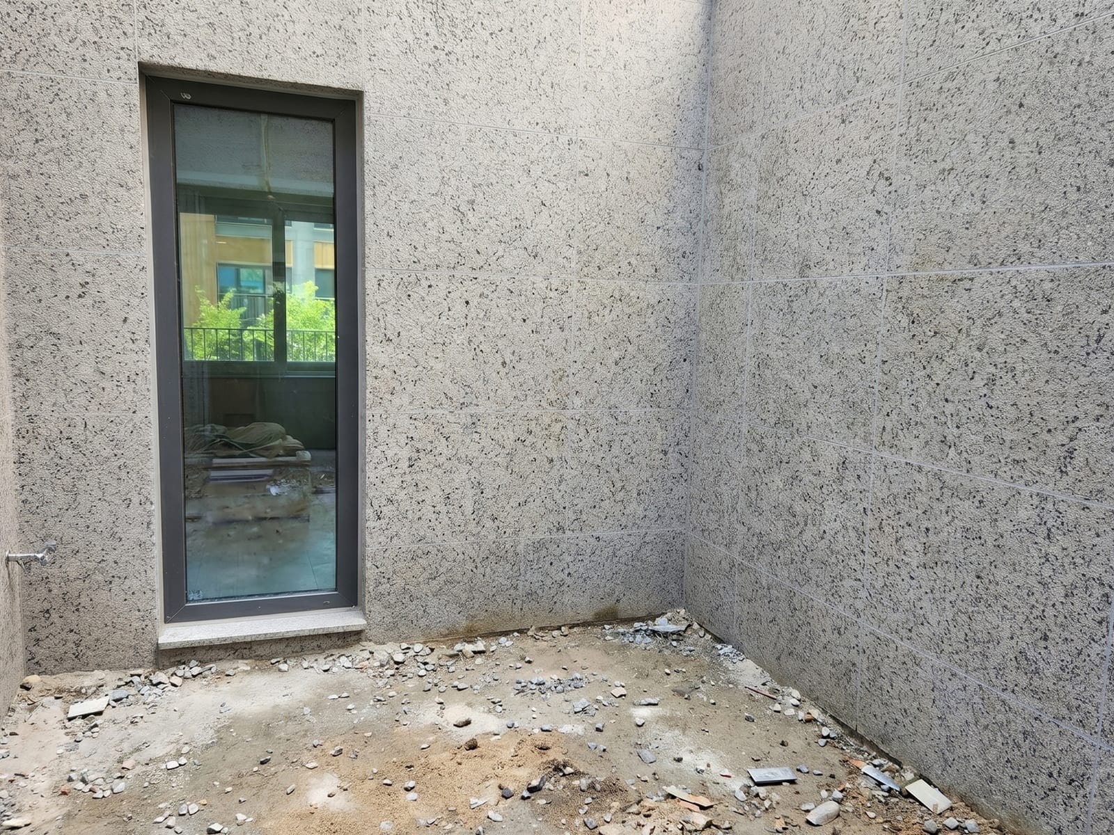 양주시 타운하우스 중정 — 인조조경 시공 전, 노출 콘크리트 벽과 정리되지 않은 바닥만 있는 빈 중정 모습