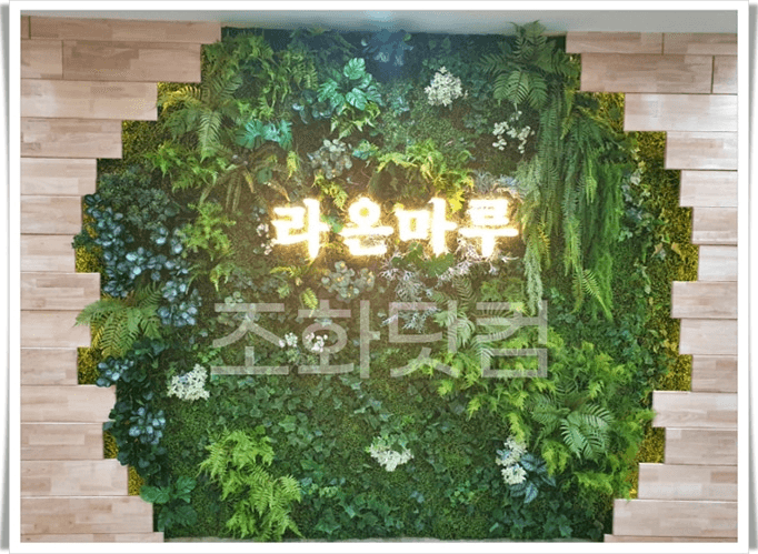 원주교육원 — 기관명 사인을 둘러싼 식물 액자와 따뜻한 조명
