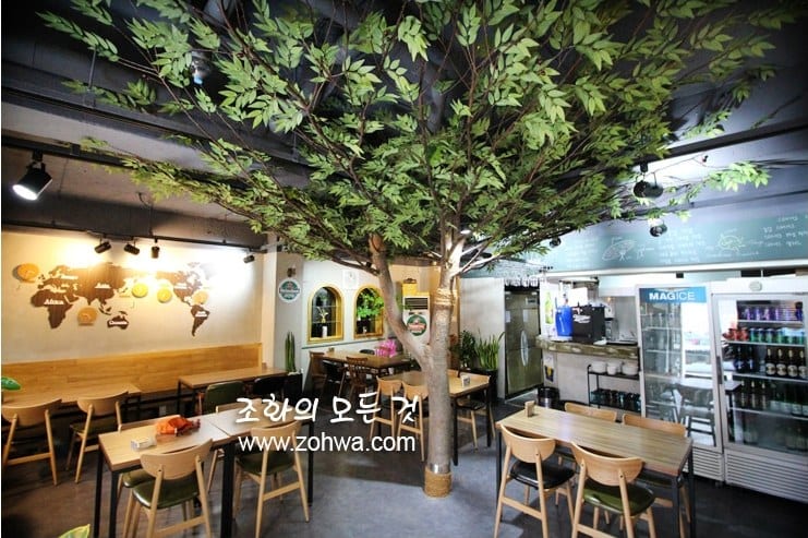 고양 이태리제이치킨 — 세계지도 벽과 올리브나무