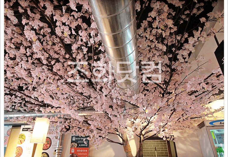전주 육회공작소 전북대점 — 천장 벚꽃과 기둥이 이어지는 좌석 위 전경