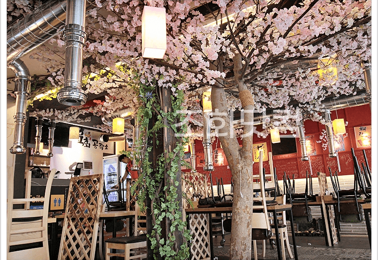 전주 육회공작소 전북대점 — 초롱등과 아이비 기둥이 놓인 저녁 좌석