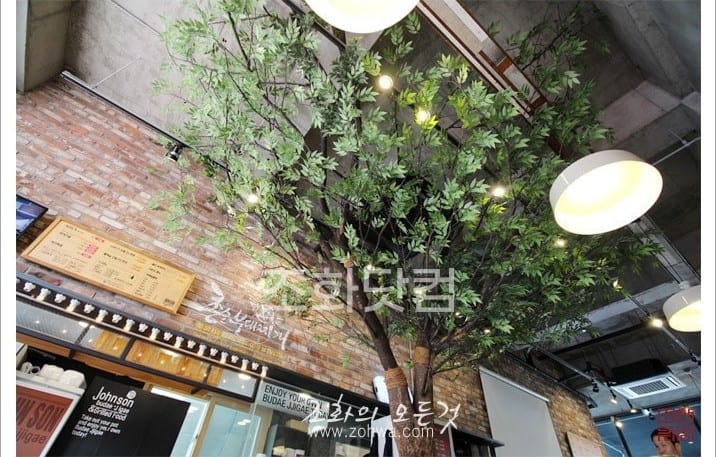 인천 존슨부대찌개 구월점 — 벽돌 벽과 어우러진 나무