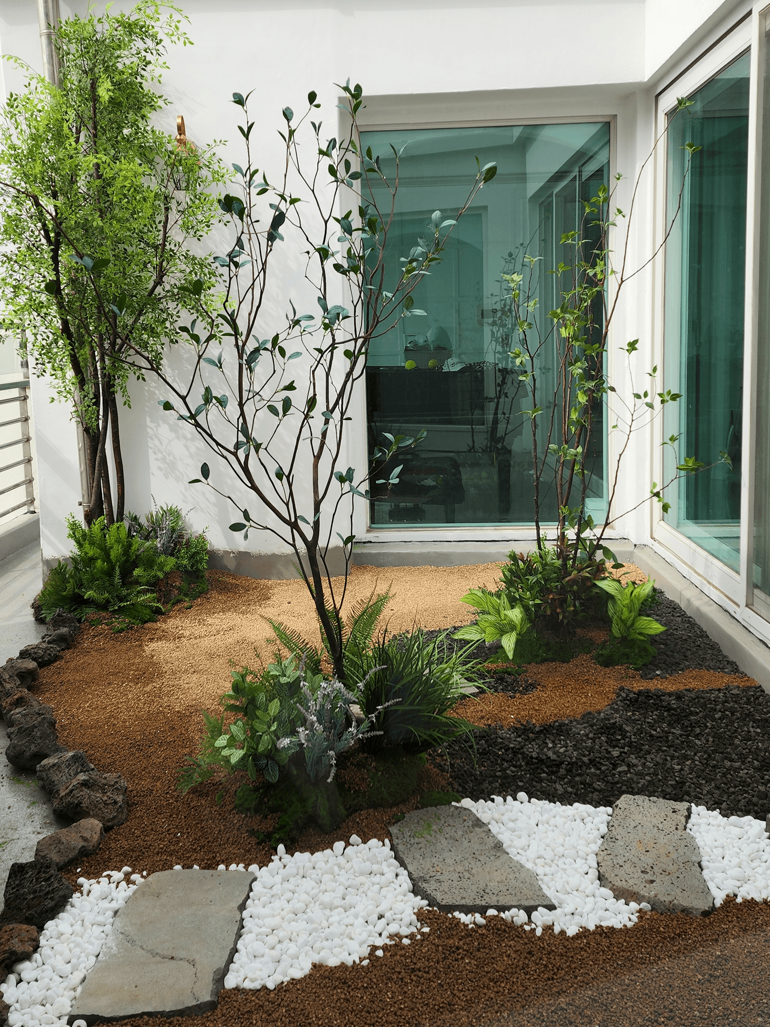 고양시 덕이동 펜트하우스 — 통유리 앞 코너에 나무와 3색 자갈 지면으로 앉힌 화단