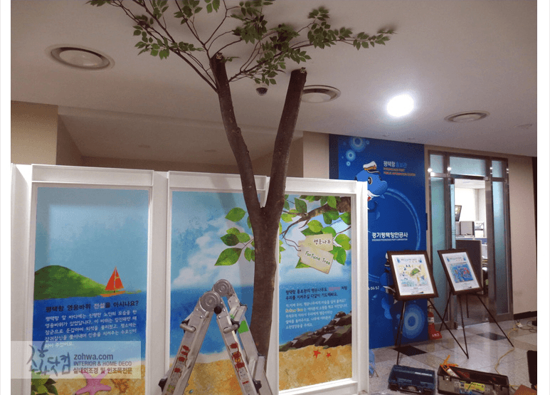 평택항 홍보관 — 홍보 패널 옆의 느티나무