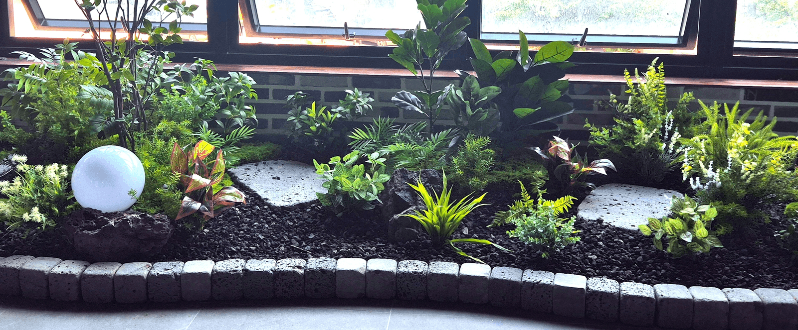 고양 소플러스 상암점 — 화산석·판석 사이에 배치를 계획해 앉힌 화단 조명