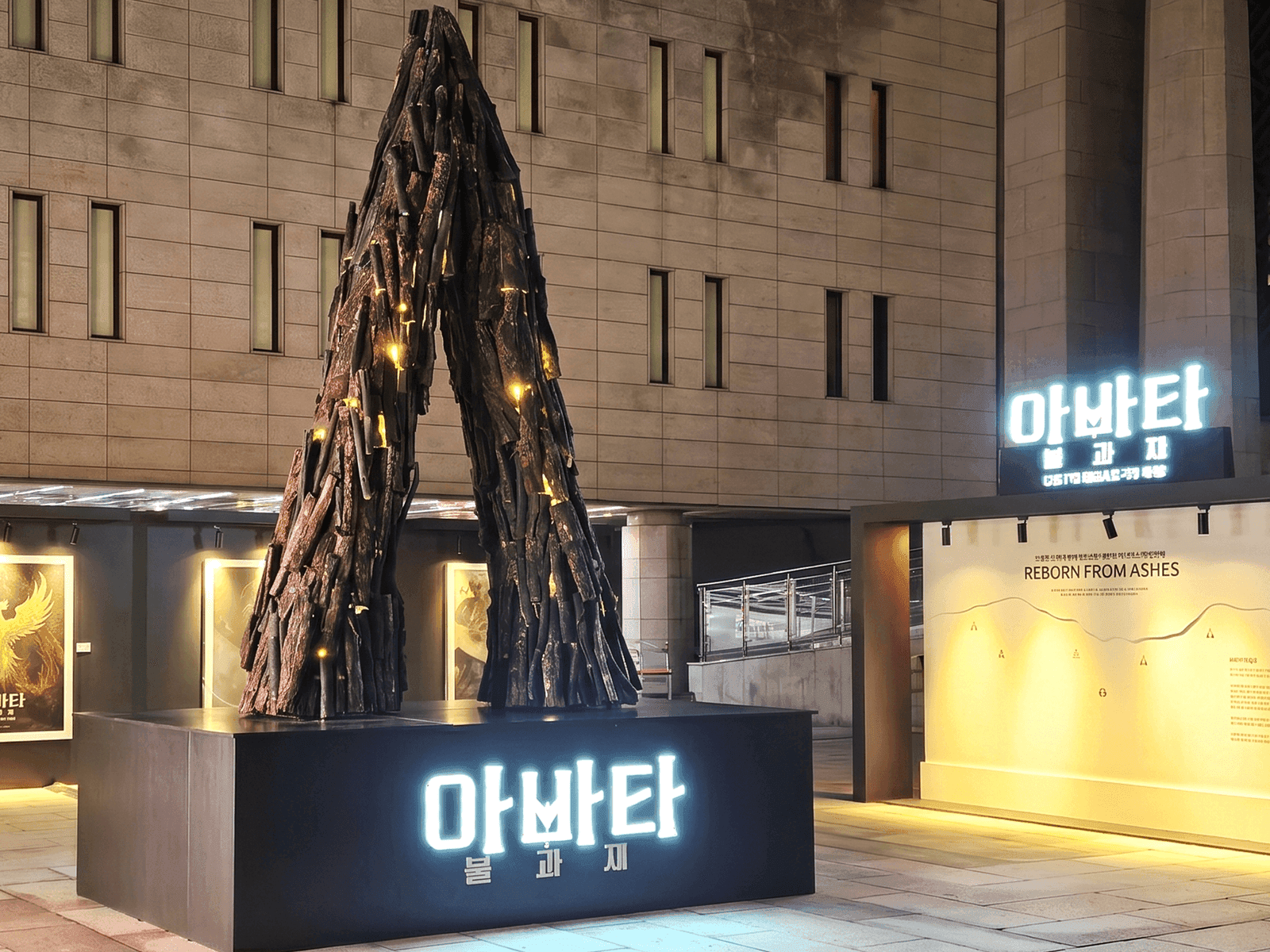 서울 세종문화회관 — 측면에서 본 넝쿨나무 A자 조형물과 'REBORN FROM ASHES' 사인